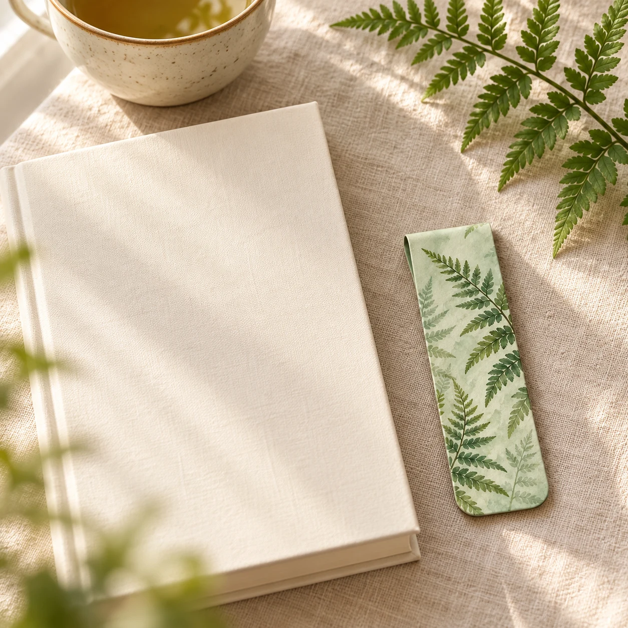 Bookmarks beside an open book on a linen-covered table